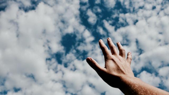 A hand points to the sky.